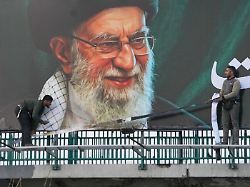 arbeiter montieren eine plakatwand mit dem portraet des verstorbenen iranischen obersten fuehrers chamenei