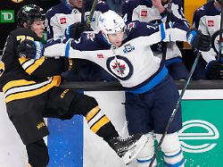 boston bruins left wing lukas reichel left is held back by winnipeg jets defenseman dylan demelo during the first period of an nhl hockey game thursday march 19 2026 in boston