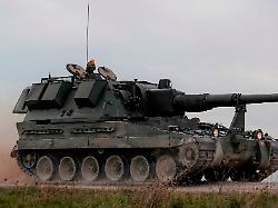 british army as 90 self propelled artillery howitzer gun hurtling along creating clouds of dust in a demonstration of firepower