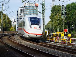 cntv bahnsanierung brueckenarbeiten arbeiter der db bahn arbeiten mit schutzkleidung bei laufenden bahnverkehr ice mit bagger krahn an neuen gleisen verlegen brueckenteile schienen und betonschwellen