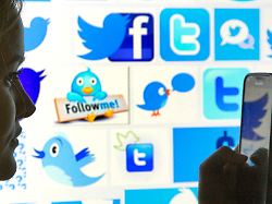 die silhouette einer frau mit einem smartphone in der hand ist vor twitter logos zu sehen am 12 01 2016