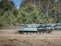 drei kampfpanzer leopard bewegen sich im rahmen einer uebung in der oberlausitz durch das gelaende