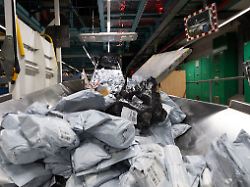 ein berg an postsendungen liegt auf einem foerderband