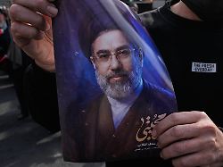 ein mann haelt ein plakat von modschtaba chamenei dem nachfolger seines verstorbenen vaters ajatollah ali chamenei als oberster fuehrer waehrend einer kundgebung zu seiner unterstuetzung