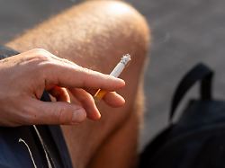 ein mann raucht eine zigarette in badehose im freien rauchen gilt als gesundheitsschaedliches genussmittel und birgt risiken durch nikotinkonsum und tabakrauch