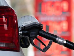 ein tankstutzen steckt an einer tankstelle in der tankoeffnung eines fahrzeugs