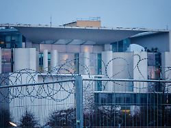 ein mit stacheldraht behangener bauzaun steht am fruehen morgen vor dem bundeskanzleramt berlin 10 03 2026
