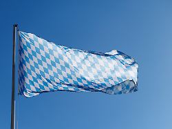 eine bayernflagge weht am 18 03 2025 an einem fahnenmast vor dem blauen himmel in muenchen bayern im wind