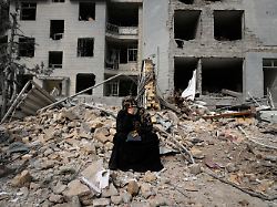 eine frau sitzt auf den truemmern eines wohnhauses das am vergangenen montag 09 03 2026 waehrend der amerikanisch israelischen luftangriffe beschaedigt wurde