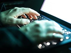 eine person tippt mit den fingern auf einer beleuchteten laptop tastatur