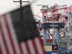 eine us flagge haengt im hafen vor containern