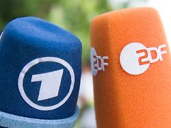 fernsehmikrofone mit den logos von ard und zdf werden vor beginn einer pressekonferenz nebeneinander gehalten