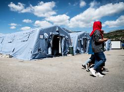 fluechtlinge gehen vor reihen von zelten in einem fluechtlingscamp fuer gefluechtete aus afghanistan am 2 september 2021 in avezzano italien