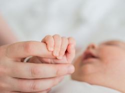 happy family tiny newborn infant baby little hand on mother hand palm newborn baby holding parent finger after birth mom baby at home support protection of new life