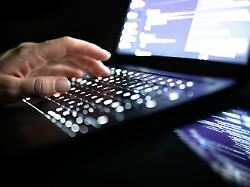 illustration 14 12 2025 na berlin eine person tippt mit den fingern auf einer beleuchteten laptop tastatur 1