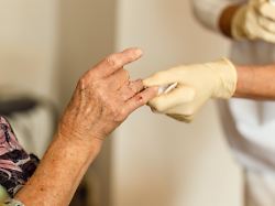 pflegeschwester behandeln eine fingerwunde eines aelteren patienten waehrend eines professionellen in home besuches modellfreigabe vorhanden