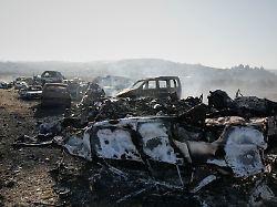 rauch steigt von verbrannten autos auf einem schrottplatz auf den israelische siedler in der nacht zuvor in der stadt hawara nahe nablus im westjordanland angezuendet haben