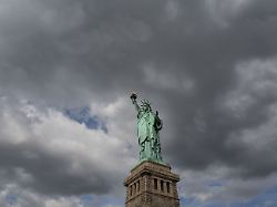 reise usa vereinigte staaten von nordamerika amerika new york wahrzeichen freiheitsstatue statue of liberty symbol stimmung wolken himmel liberty island flagge fahne sternbanner foto franz neumayr 29 8