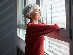 smiling woman enjoying sunlight through window indoors model released symbolfoto property released rbf10241