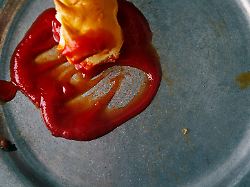 smudged ketchup and leftover food on a dirty dish close up azf01025