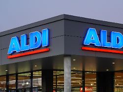 aldi lebensmitteldiscounter leuchtreklame ueber dem eingang einer filiale daemmerung