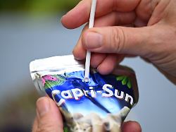 archiv 27 08 2024 baden wuerttemberg stuttgart ein trinkpaeckchen von capri sun mit einem papierstrohhalm steht auf einem tisch