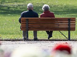 aelteres paar sitzend auf einer parkbank im stadtpari von mainz in rheinland pfalz