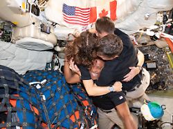 auf diesem von der nasa zur verfuegung gestellten bild umarmt sich die artemis 2 crew christina koch l jeremy hansen oben reid wiseman r und victor glover unten in der orion kapsel