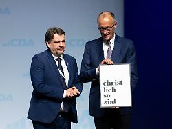 bundeskanzler friedrich merz r cdu hat als dank fuer seinen besuch von dennis radtke cdu cda bundesvorsitzender ein geschenk bekommen