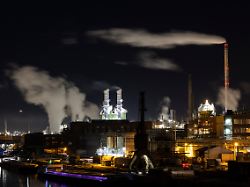 dampf aus industrieschornsteinen zieht ueber den industriepark hoechst