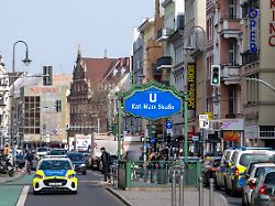 das eingangsschild zum u bahnhof karl marx strasse steht an der gleichnamigen strasse im berliner stadtteil neukoelln waehrend fahrzeuge im strassenverkehr an den eingaengen zur u bahn vorbeifahren