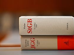 das strafgesetzbuch stgb und das jugendgerichtsgesetz jgg liegen in einem gerichtssaal auf einem tisch