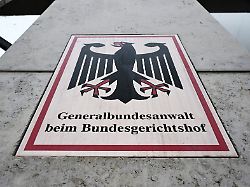 ein hinweisschild mit bundesadler und dem schriftzug generalbundesanwalt beim bundesgerichtshof aufgenommen vor der bundesanwaltschaft