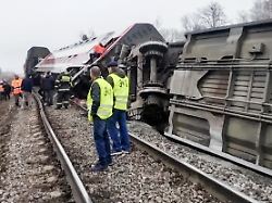 ein entgleister personenzug liegt nahe den gleisen einsatzkraefte stehen auf dem bahndamm zwischen umgestuerzten waggons das unglueck ereignete sich auf der strecke moskau nach tscheljabinsk