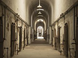 ein unheimlicher verlassener gefaengnisflur mit verfallenen waenden und alten tueren die den korridor saeumen