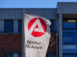 eine flagge mit dem logo der arbeitsagentur und dem schriftzug agentur fuer arbeit weht an der einfahrt in der strasse horstweg