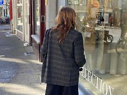 eine frau in kleidung im oversize look vor einem schaufenster