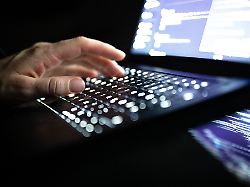 eine person tippt mit den fingern auf einer beleuchteten laptop tastatur 2