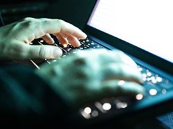 eine person tippt mit den fingern auf einer beleuchteten laptop tastatur