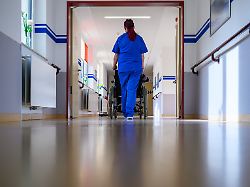 eine pflegerin der geriatrie im drk krankenhaus chemnitz schiebt einen patienten im rollstuhl ueber die station die geriatrie ist auf die medizinische versorgung aelterer patienten spezialisiert