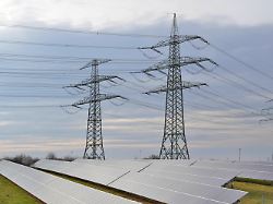 energieinfrastruktur erzeugung von gruenem strom und effizienter stromtransport freileitungsmasten mit hochspannungsleitungen neben einem solarpark elektrosmog sicherheitsrisiken fuer voegel