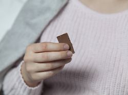 frau haelt stueck schokolade in hand woman holding piece of chocolate in her hand