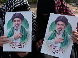 frauen halten plakate des neuen iranischen staatsoberhaupts modschtaba chamenei waehrend einer kampagne zur unterstuetzung der regierung auf dem platz der islamischen revolution