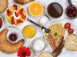fruehstueck mit muesli marmelade kaffee ruehrei fruechten broetchen und orangensaft von oben