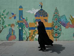 head to toe veiled women walk past a mural depicting a mosque on enqelab e eslami islamic revolution street in downtown tehran iran saturday april 25 2026