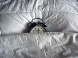 illustration ein fuenf vor zwoelf anzeigender wecker liegt am 25 12 2013 unter einer bettdecke