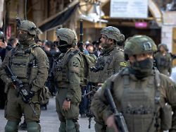 israeli soldiers stand guard as israeli settlers walk in hebron s old city in the occupied west bank on december 13 2025 forces were deployed in the area as settlers entered under army protection