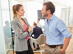 lockeres gespraech zwischen zwei business team kollegen im buero