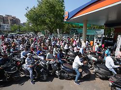 motorrollerfahrer stehen an einer tankstelle vor den zapfsaeulen schlange weil sie einen moeglichen treibstoffmangel aufgrund des iran kriegs befuerchten