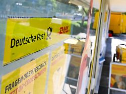 produktion 17 04 2026 baden wuerttemberg stuttgart ein schild mit den logos der post und dhl haengt vor einer postfiliale das flaechendeckende netz an postfilialen hat luecken